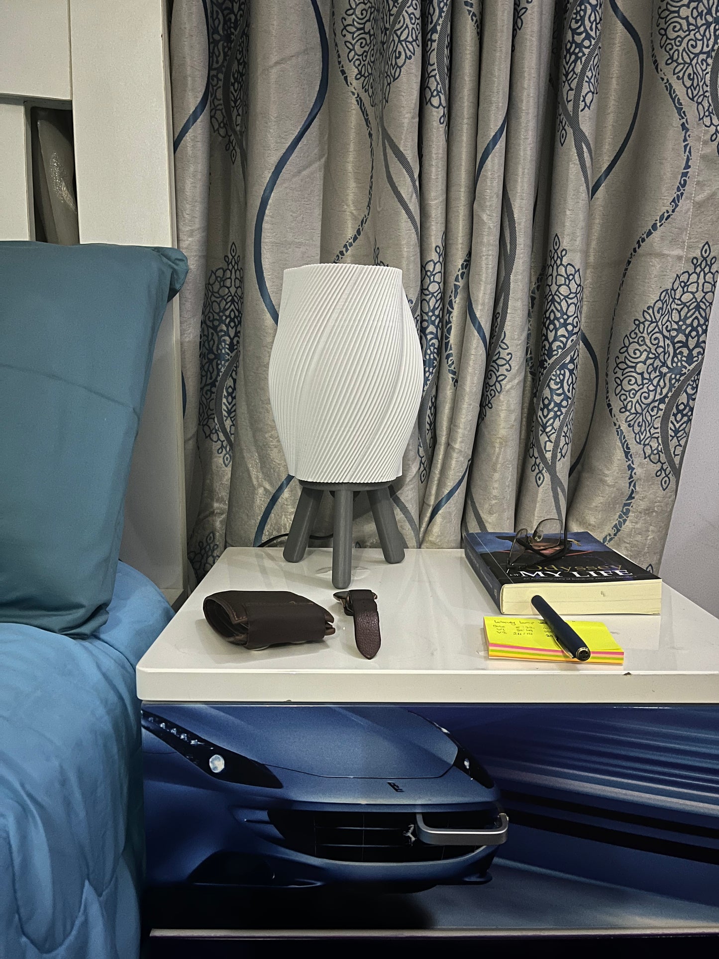 3D printed grey Taifū bedside/table lamp on a bedside table with lights off