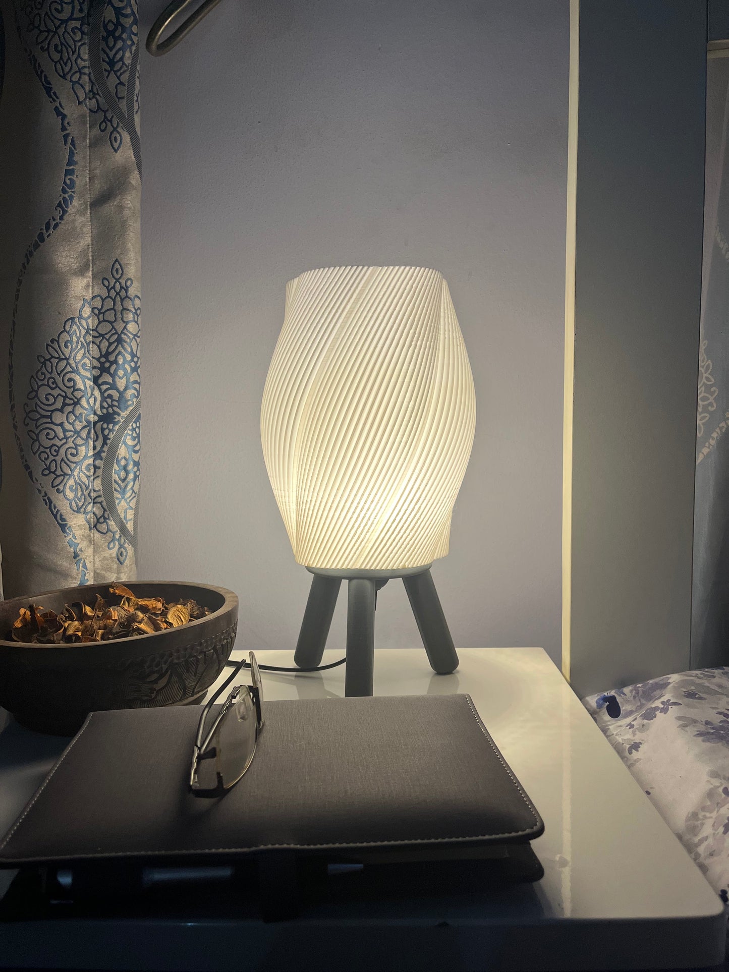 3D printed black Taifū bedside/table lamp on a bedside table